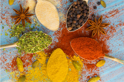 An array of colorful spices in wooden scoops