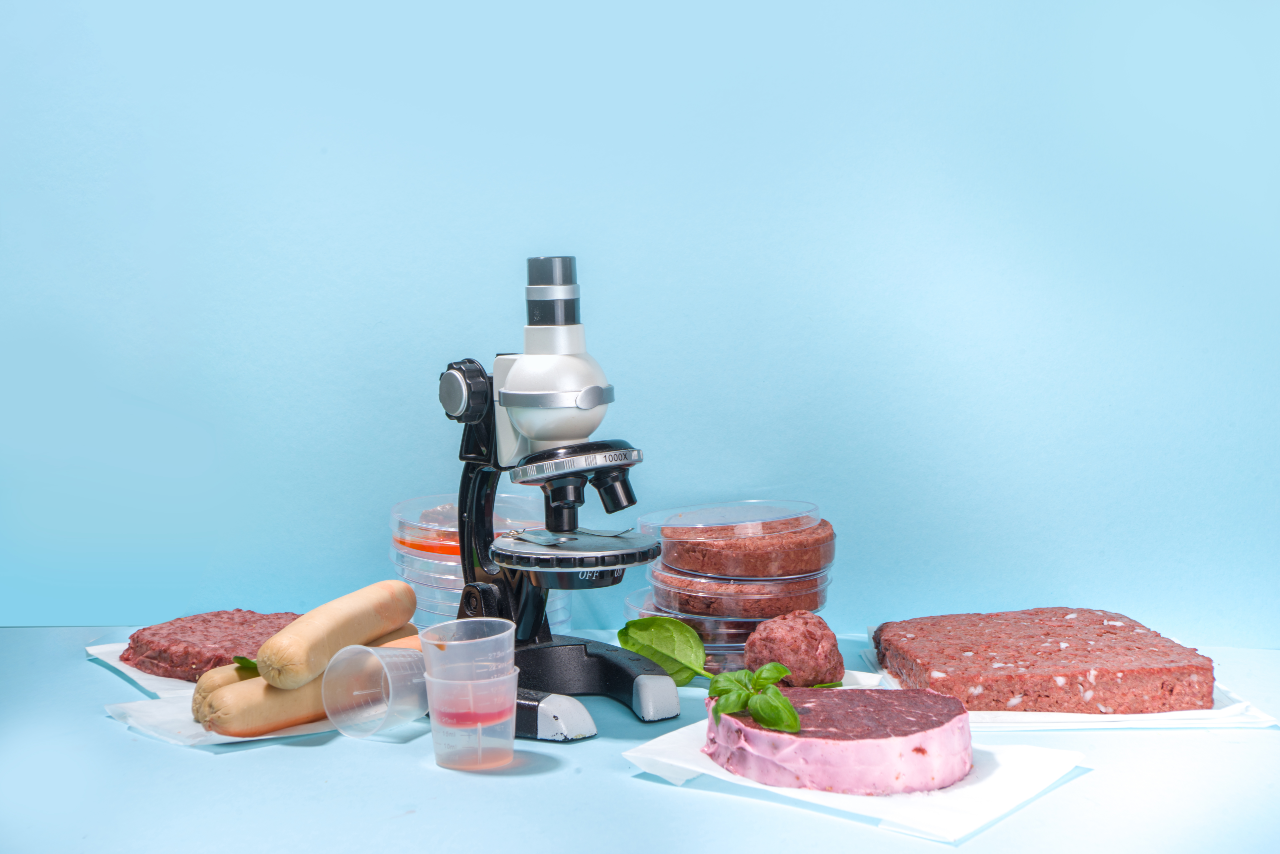 A microscope appears next to uncooked meats.