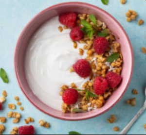 Yogurt in a bowl with raspberries and granola and oats.