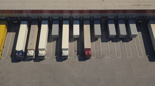 A busy distribution center loads several semi trucks.