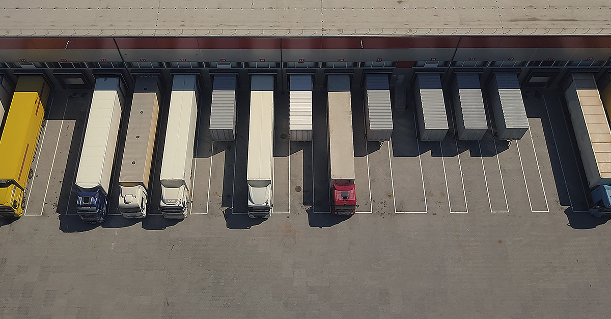 A busy distribution center loads several semi trucks.