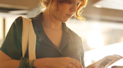 A woman inspects a food label in a store.