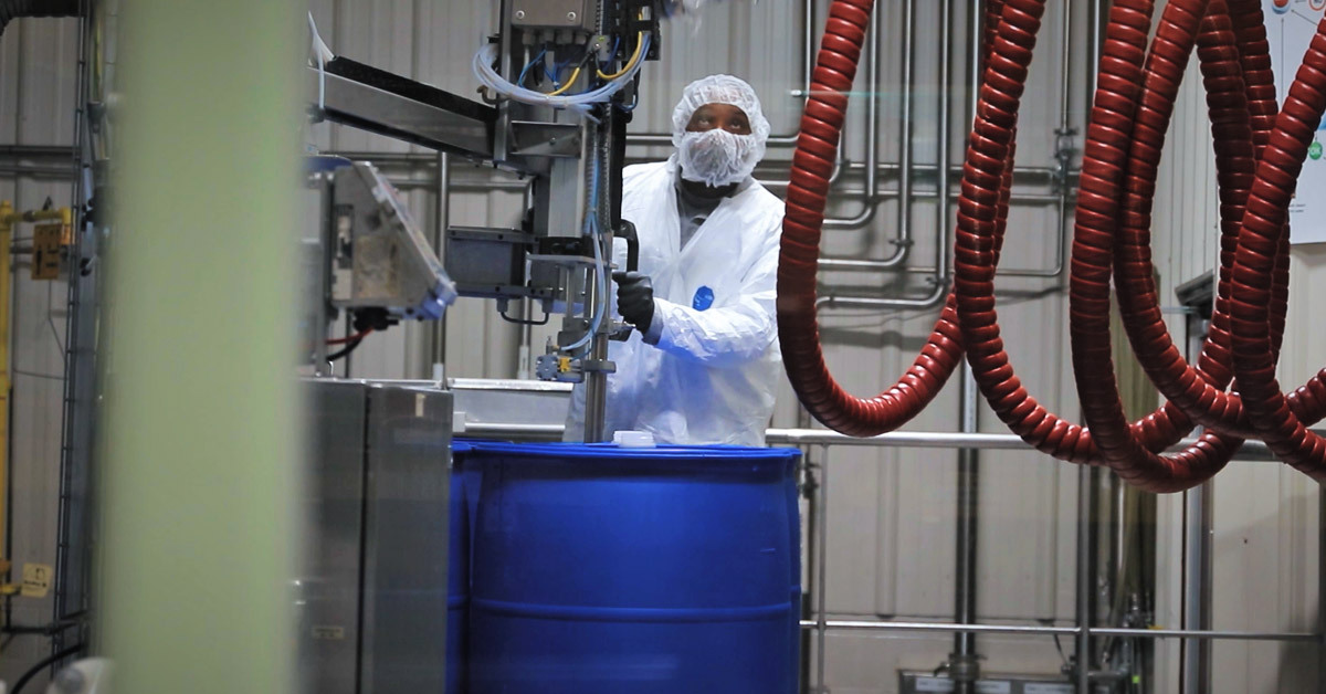 A Tilley Distribution employee fills a blue drum in the company's chemical distribution facility in Maryland.