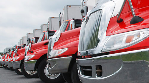 Long row of red semi-trucks lined up.