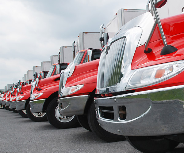 Long row of red semi-trucks lined up.