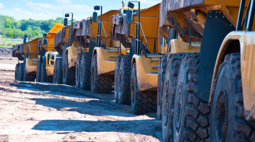 Heavy duty dump trucks lined up for a project.