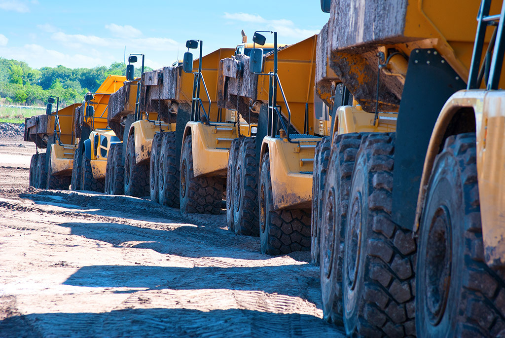 Heavy duty dump trucks lined up for a project.