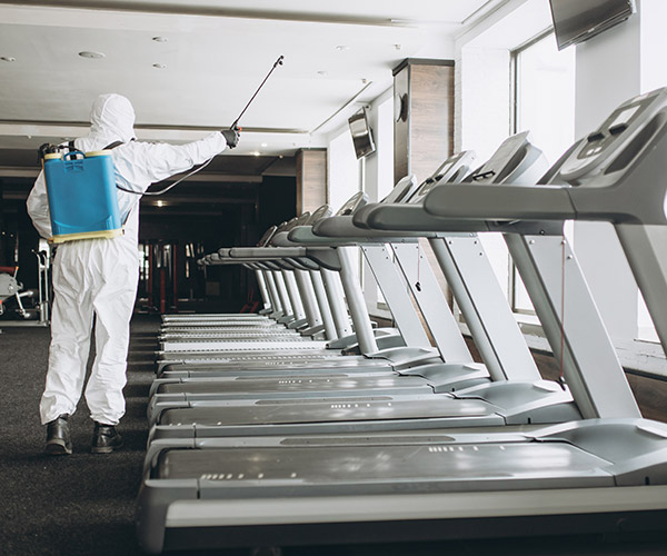 Spray cleaning the treadmills at a gym.