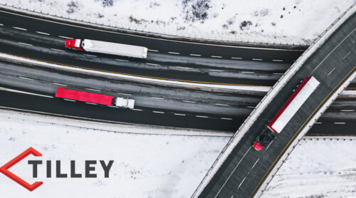 Trucks delivering products on a snowy highway.