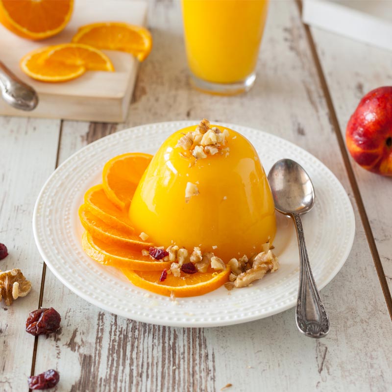 An orange flan desert with some orange slices.